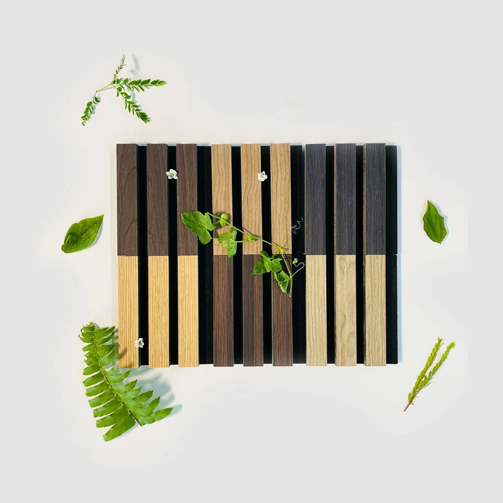 Samples: Square arrangement of alternating dark and light wooden slats, accented with green leaves and small white flowers on a light gray background, with extra leaves scattered around.