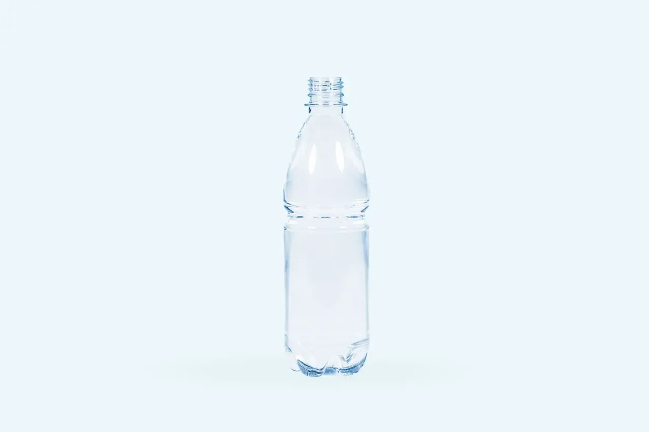 A clear plastic water bottle without a cap, partially filled with water, stands upright against a plain light blue background, reminiscent of the clean lines and minimalist style of Stilj™ Sustainable Acoustic Wood Paneling.
