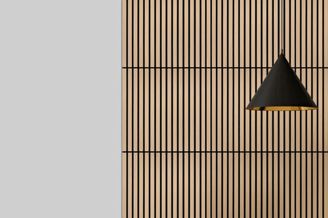 A modern black pendant lamp hangs in front of a wall with vertical Acoustic Wood Slat Panels. The left side of the image features a plain light gray section, contrasting with the patterned wood on the right. Perfect for stylish Acoustic Wood Slat Panel locations.